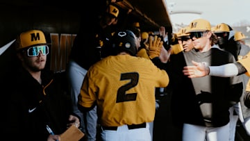 Left fielder Brock Daniels celebrates in the dugout. 