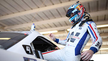 Connor Zilisch, driver of the No. 88 WeatherTech Chevrolet, enters his car in the garage area at Phoenix Raceway.