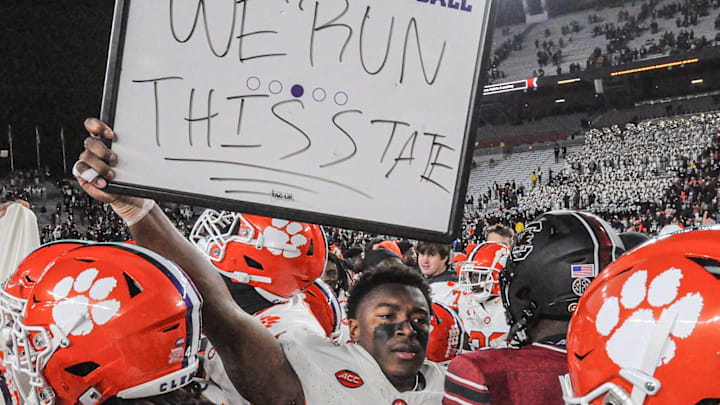 Nov 25, 2023; Columbia, South Carolina, USA; Clemson Tigers linebacker Barrett Carter (0) holds a sign \"We Run This State\" near South Carolina Gamecocks linebacker Grayson Howard (5) after defeating South Carolina at Williams-Brice Stadium.  Clemson won 16-7. Mandatory Credit: Ken Ruinard-Imagn Images