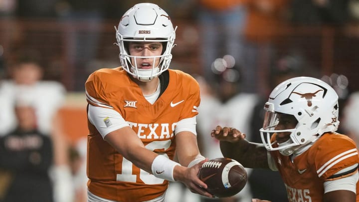 Texas Longhorns quarterback Arch Manning (16) hands off the ball during the game against Texas Tech at Darrell K Royal Texas Memorial Stadium on Friday, Nov. 24, 2023.