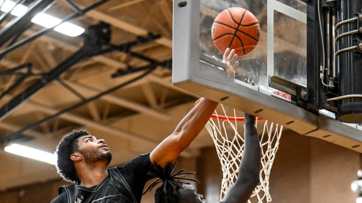 Team Goodfellas' and Michigan State's Kur Teng, right, scores as his MSU teammate Jaden Akins with Team Motorcars defends in the game on Tuesday, July 9, 2024, during the Moneyball Pro-Am at Holt High School.