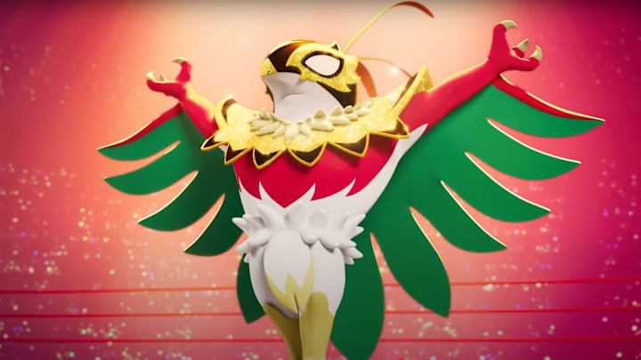 Mega Hawlucha. A humanoid bird Pokémon with white and red feathers and green wings wearing a black and gold mask.