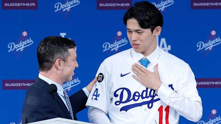 Dodgers president of baseball operations Andrew Friedman and pitcher Roki Sasaki talk during a press conference at Dodger Stadium.