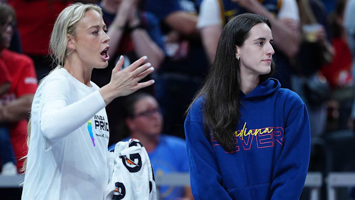 Sophie Cunningham and Caitlin Clark watch the Fever's 85-75 loss to the Sparks on Thursday night from the bench.