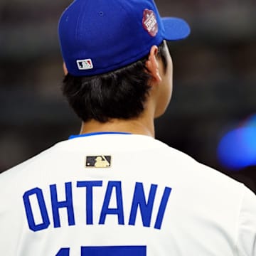 Shohei Ohtani wearing Los Angeles Dodgers jersey with gold MLB logo on the back. 