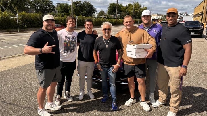 Six Vikings pose with Guy Fieri outside a Twin Cities restaurant. 