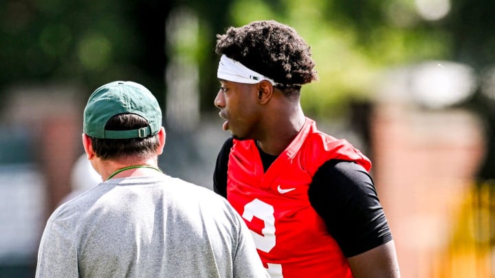 Michigan State quarterback Aidan Chiles, right, talks with head coach Jonathan Smith during the first day of football camp on Tuesday, July 30, 2024, in East Lansing.