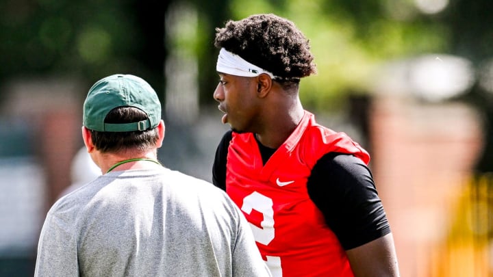 Michigan State quarterback Aidan Chiles, right, talks with head coach Jonathan Smith during the first day of football camp on Tuesday, July 30, 2024, in East Lansing.