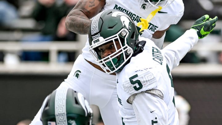 Michigan State's Nathan Carter, center, celebrates his touchdown with teammates Jack Velling,