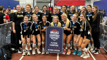 The Plant high school volleyball team poses behind their championship banner after winning the 2024 Nike Tournament of Champions Southeast in Orlando.