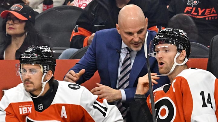 Oct 13, 2025; Philadelphia, Pennsylvania, USA; Philadelphia Flyers head coach Rick Tocchet talks with Philadelphia Flyers center Sean Couturier (14) and right wing Travis Konecny (11) against the Florida Panthers during the first period at Wells Fargo Center. Mandatory Credit: Eric Hartline-Imagn Images
