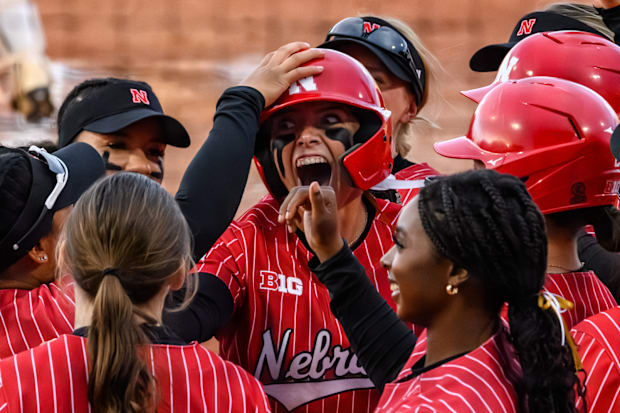 Ava Kuszak celebrates her home run with teammates at home plate. 