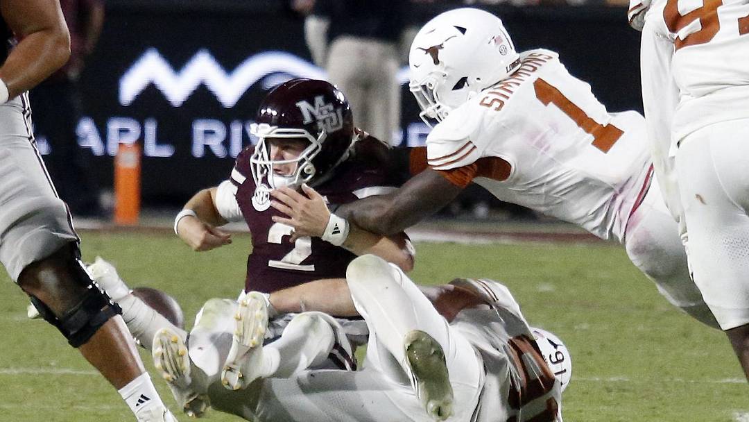 Texas Longhorns defensive linemen Ethan Burke (91) and Texas Longhorns defensive linemen Colin Simmons (1) force Mississippi State Bulldogs quarterback Blake Shapen (2) to fumble during overtime at Davis Wade Stadium at Scott Field.
