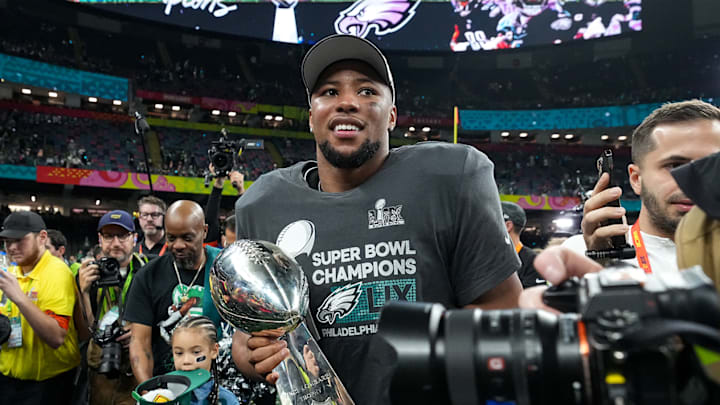 Philadelphia Eagles running back Saquon Barkley walks with the Lombardi Trophy after the team won Super Bowl LIX.