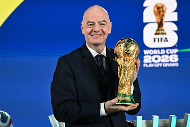 Gianni Infantino holding the World Cup trophy.