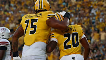 Sept 27, 2025; Columbia, Missouri, USA; Missouri Tigers offensive lineman (75, left) celebrates the touchdown of running back Jamal Roberts (20) in a game against UMass at Faurot Field at Memorial Stadium.