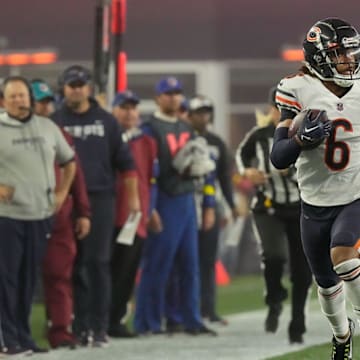 Kyler Gordon returns an interception against New England as Bill Belichick watches on from the sidelines in a Bears 2022 win.