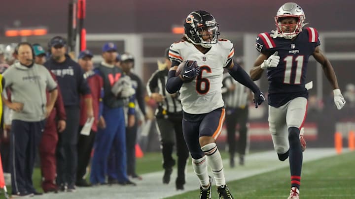 Kyler Gordon returns an interception against New England as Bill Belichick watches on from the sidelines in a Bears 2022 win.