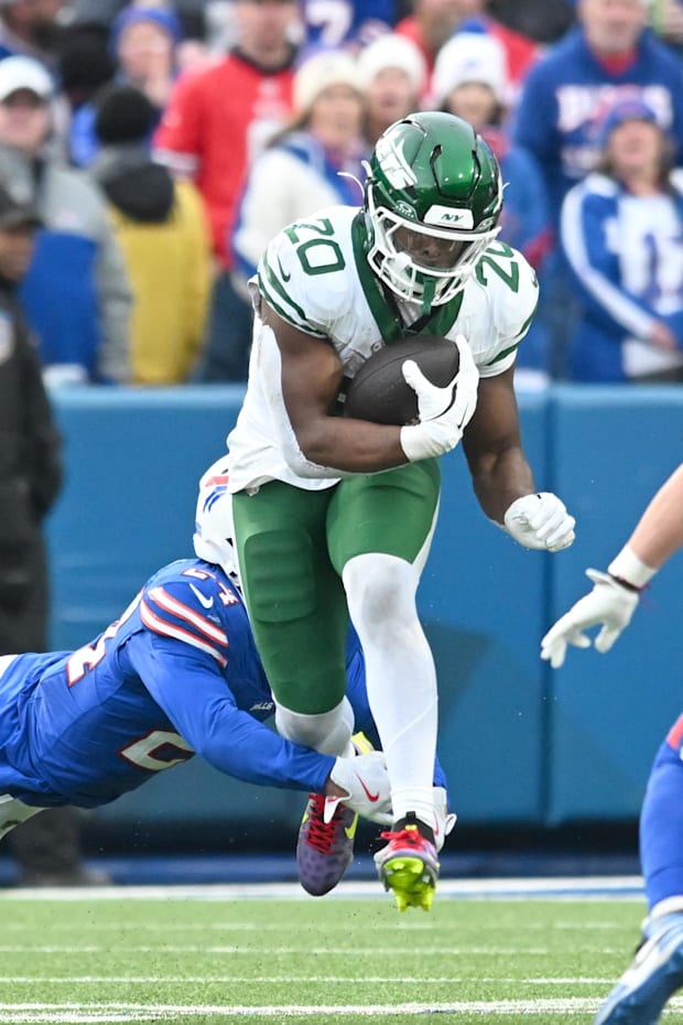 New York Jets running back Breece Hall (20) tries to avoid a tackle by Buffalo Bills safety Cole Bishop
