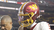 Washington Commanders quarterback Jayden Daniels is helped off the field after an injury.