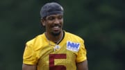 Jun 5, 2024; Ashburn, VA, USA; Washington Commanders quarterback Jayden Daniels (5) smiles on the field during an OTA workout at Commanders Park. Mandatory Credit: Geoff Burke-USA TODAY Sports