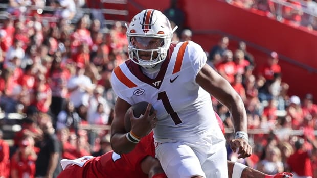 Virginia Tech Hokies quarterback Kyron Drones on a rushing attempt during a college football game in the ACC.