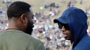 Jackson State coach Deion Sanders, right, and Mississippi Valley State head coach Vincent Dancy, left, visit before the SWAC Championship game at Veteran's Memorial Stadium in Jackson, Miss.,