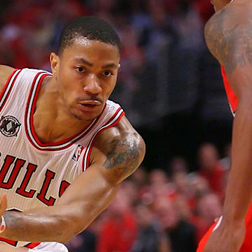 May 10, 2011; Chicago, IL, USA; Chicago Bulls point guard Derrick Rose (left) drives past Atlanta Hawks guard Jeff Teague (0) during the second half in game five of the second round of the 2011 NBA playoffs at the United Center. The Bulls defeated the Hawks 95-83. 