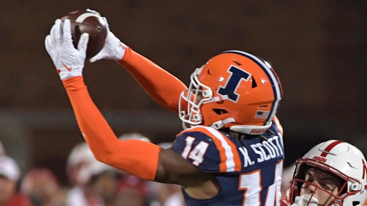 Oct 6, 2023; Champaign, Illinois, USA; Illinois Fighting Illini defensive back Xavier Scott (14) intercepts the ball in front of intended Nebraska Cornhuskers wide receiver Alex Bullock (84) during the second half at Memorial Stadium. Mandatory Credit: Ron Johnson-Imagn Images