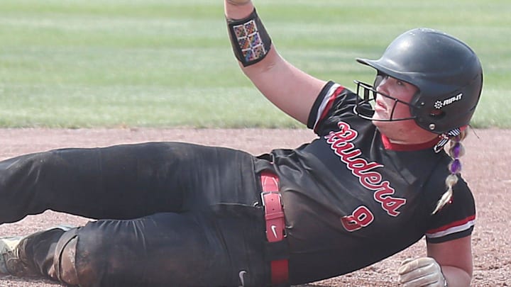 Williamsburg's Taylor Pitlick (8) slides safely on the third base as Davenport Assumption's Alexis Pilgram (36) attempts to tag during the fourth inning in the 3A Iowa high school state softball tournament championship at Rogers Sports complex on Friday, July 26, 2024, in Fort Dodge, Iowa.