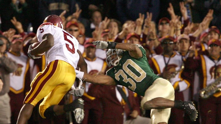 Oct. 15, 2005; South Bend, IN, USA; Southern California Trojans running back Reggie Bush avoids the tackle of Notre Dame Fighting Irish Mike Richardson on his way to a touchdown in the fourth quarter of USC's 34-31 win over Notre Dame Saturday Oct. 15 at Notre Dame Stadium. Mandatory Credit: Photo By Matt Cashore-USA TODAY Sports Copyright (c) 2005 Matt Cashore