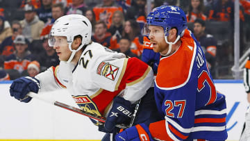 Dec 16, 2023; Edmonton, Alberta, CAN; Edmonton Oilers defensemen Brett Kulak (27)  battles with Florida Panthers forward Eetu Luostarinen (27) during the second period at Rogers Place. Mandatory Credit: Perry Nelson-USA TODAY Sports