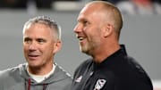 Oct 8, 2022; Raleigh, North Carolina, USA; Florida State Seminoles head coach Mike Norvell (center) and North Carolina State Wolfpack head coach Dave Doeren (right) talk prior to a game at Carter-Finley Stadium. Mandatory Credit: Rob Kinnan-Imagn Images