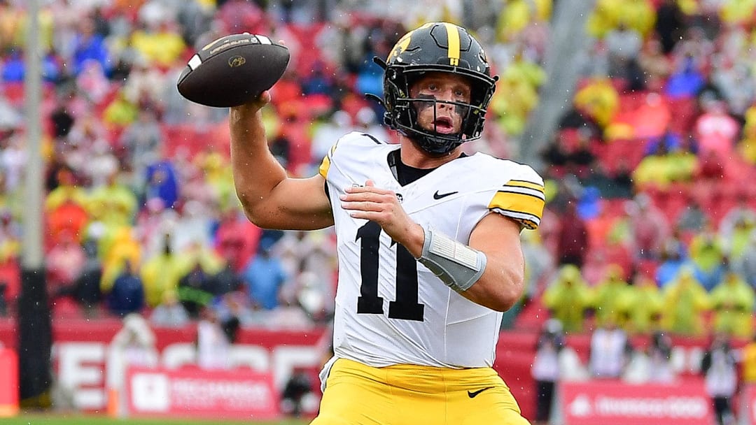 Nov 15, 2025; Los Angeles, California, USA; Iowa Hawkeyes quarterback Mark Gronowski (11) throws a touchdown pass against the Southern California Trojans during the first half at the Los Angeles Memorial Coliseum. Mandatory Credit: Gary A. Vasquez-Imagn Images
