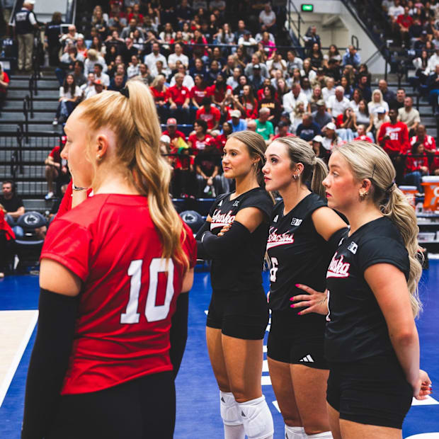 Olivia Mauch, Maisie Boesiger, Laney Choboy and Keri Leimbach watch the Huskers warm up in front of a swath of Husker fans.