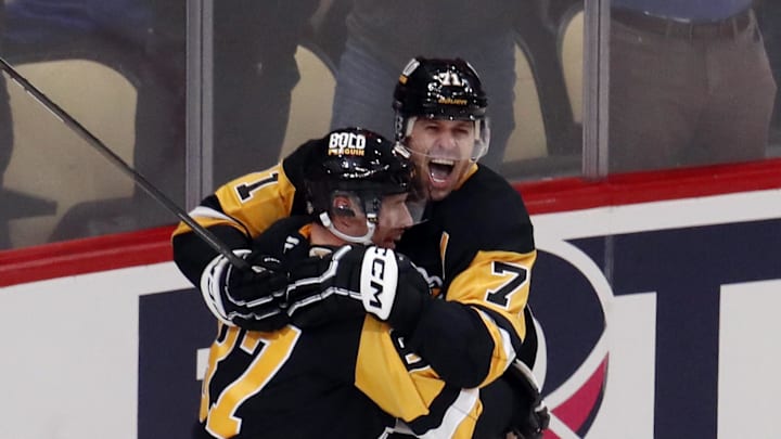 Oct 16, 2024; Pittsburgh, Pennsylvania, USA; Pittsburgh Penguins center Sidney Crosby (87) and center Evgeni Malkin (71) celebrate after Crosby scored the game winning power play goal in overtime to defeat the Buffalo Sabres at PPG Paints Arena. Mandatory Credit: Charles LeClaire-Imagn Images
