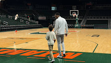 Jai Lucas walking through Watsco Center with his son after his first day with the Miami Hurricanes.