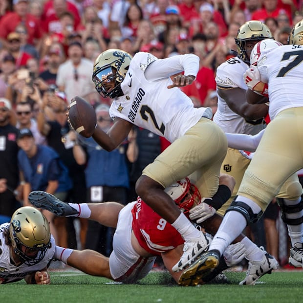 Colorado quarterback Shedeur Sanders tries to no avail to escape the grasp of Nebraska defensive lineman Ty Robinson.