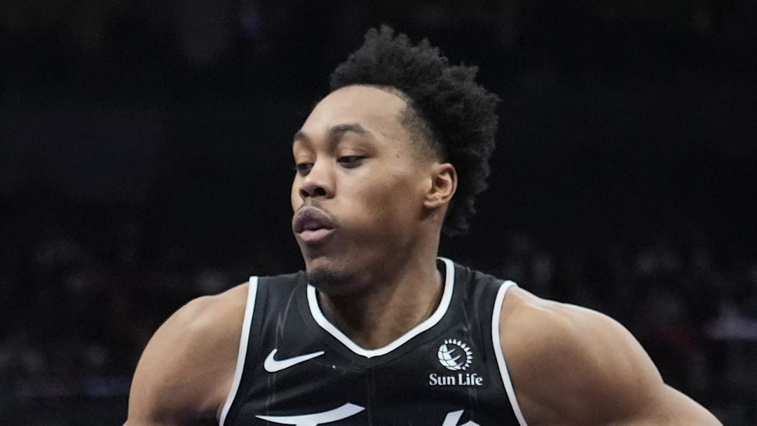 San Antonio Spurs guard De'Aaron Fox controls the ball against Toronto Raptors guard Scottie Barnes.