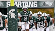 Michigan State's Aidan Chiles, center, and the Spartans take the field before the game against UCLA on Saturday, Oct. 11, 2025, at Spartan Stadium in East Lansing.