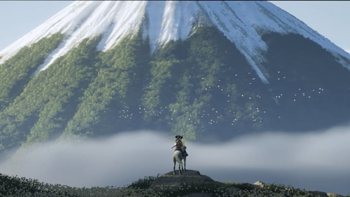 Ghost of Yotei - Atsu sits on horseback in the shadow of Mount Yotei