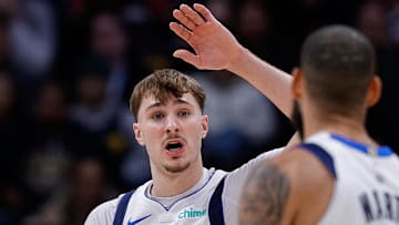 Dec 1, 2025; Denver, Colorado, USA; Dallas Mavericks forward Cooper Flagg (32) reacts with forward Caleb Martin (16) after a play in the first quarter against the Denver Nuggets at Ball Arena. Mandatory Credit: Isaiah J. Downing-Imagn Images