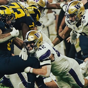 Carson Bruener (42) and Bralen Trice (8) converge on Michigan running back Blake Corum.