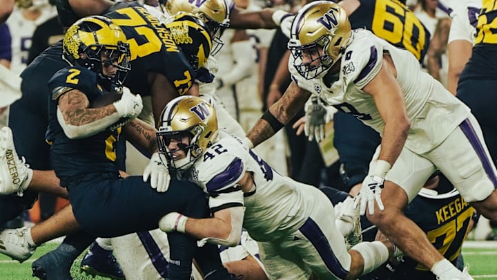 Carson Bruener (42) and Bralen Trice (8) converge on Michigan running back Blake Corum.