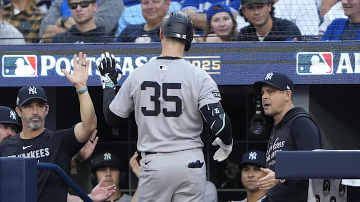 Oct 5, 2025; Toronto, Ontario, CAN; New York Yankees manager Aaron Boone (17), right, congratulates left fielder Cody Bellinger (35) after he hit a home run in the sixth inning against the Toronto Blue Jays during game two of the ALDS round for the 2025 MLB playoffs at Rogers Centre. Mandatory Credit: Kevin Sousa-Imagn Images