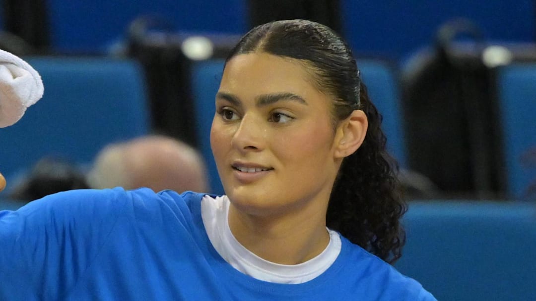 UCLA Bruins center Lauren Betts, right, wipes the brow of her sister forward Sienna Betts.