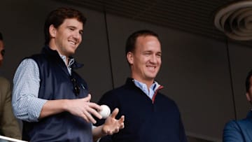 May 4, 2014; Bronx, NY, USA; New York Giants quarterback Eli Manning and Denver Broncos quarterback Peyton Manning watch the game between the New York Yankees and Tampa Bay Rays at Yankee Stadium. 