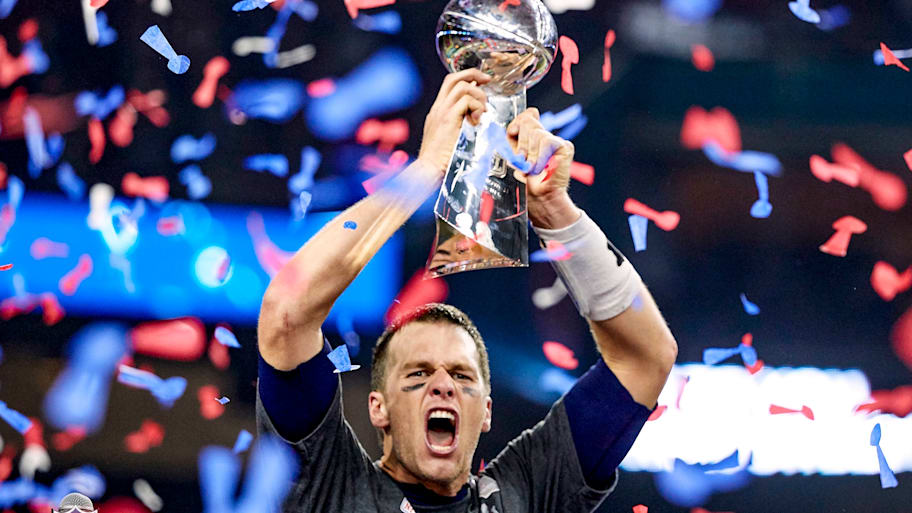 Patriots quarterback Tom Brady holding up Vince Lombardi Trophy after winning the Super Bowl over the Falcons.