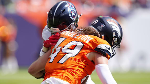 Denver Broncos linebacker Alex Singleton (49) tackles Tennessee Titans wide receiver Chimere Dike (17) in the first half.