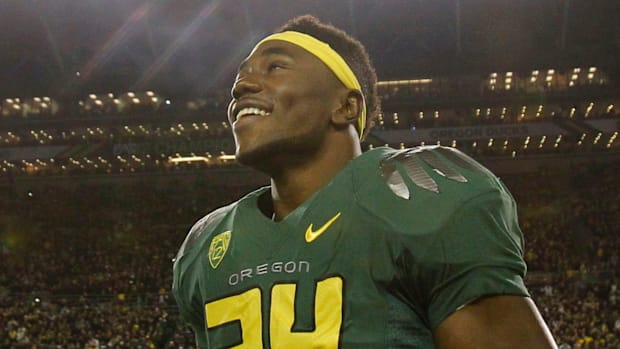 Kenjon Barner looks up at the fans as fireworks mark the end of the playing of the National Anthem before the Pac-12 Champion